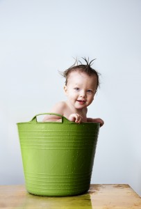 Baby bathing in green tub