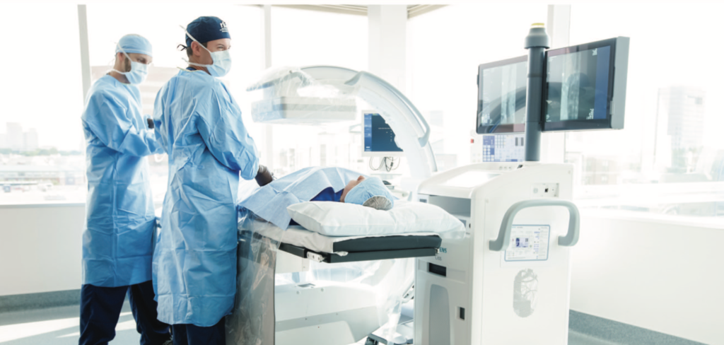 Interventional radiology technologist, Michael Rose, and medical director, Dr. Peter Stratil view images of catheters threading through an artery. This technique helps the doctors to perform several types of minimally-invasive procedures.